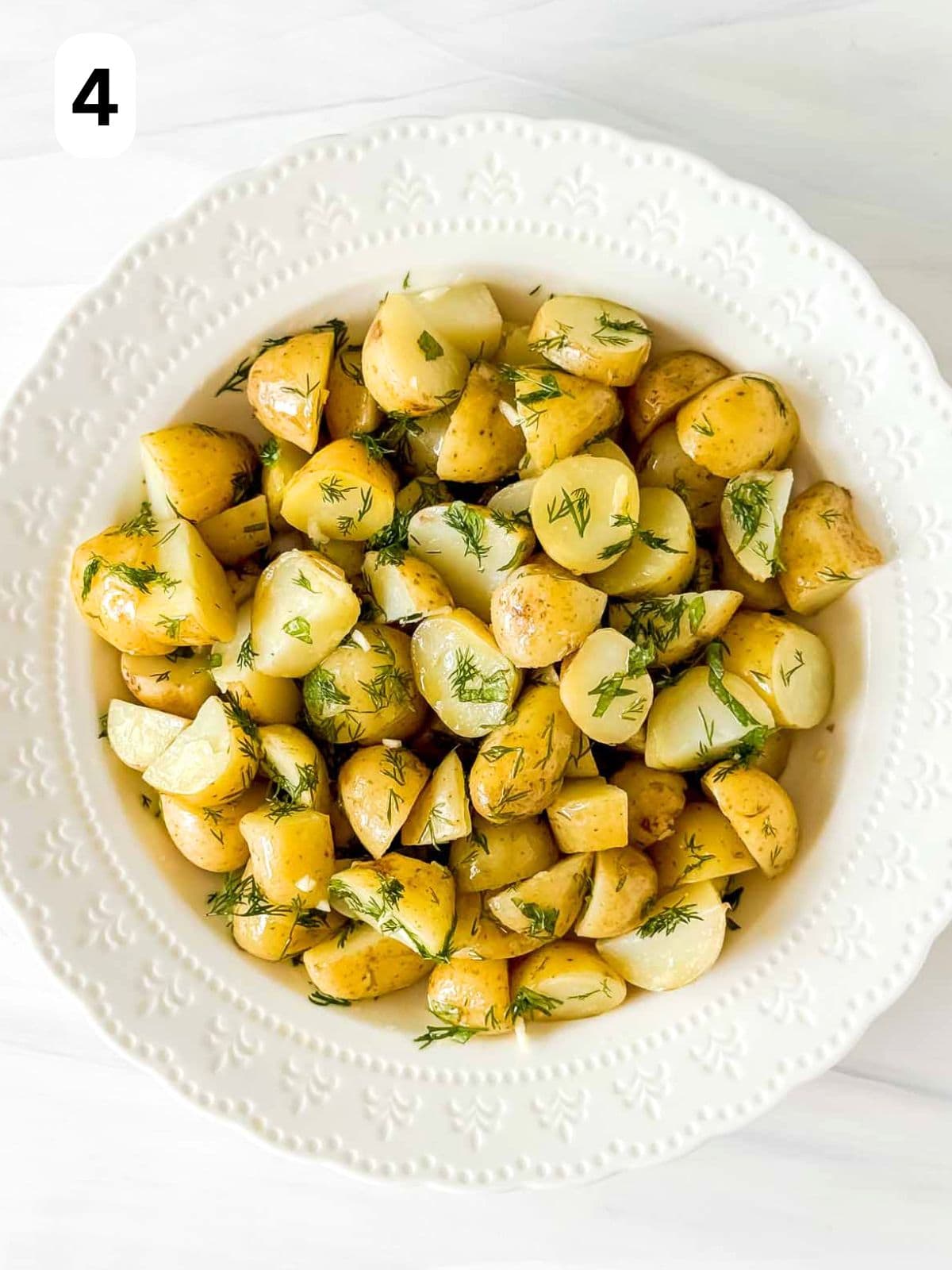 potato salad without mayo in a white bowl with herbs labelled number four.