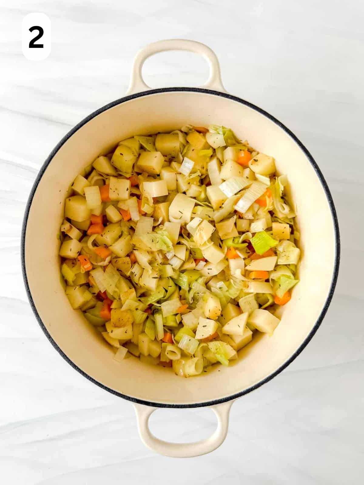 diced leek, potato, celery, carrot, onion and herbs in a soup pot labelled number two.