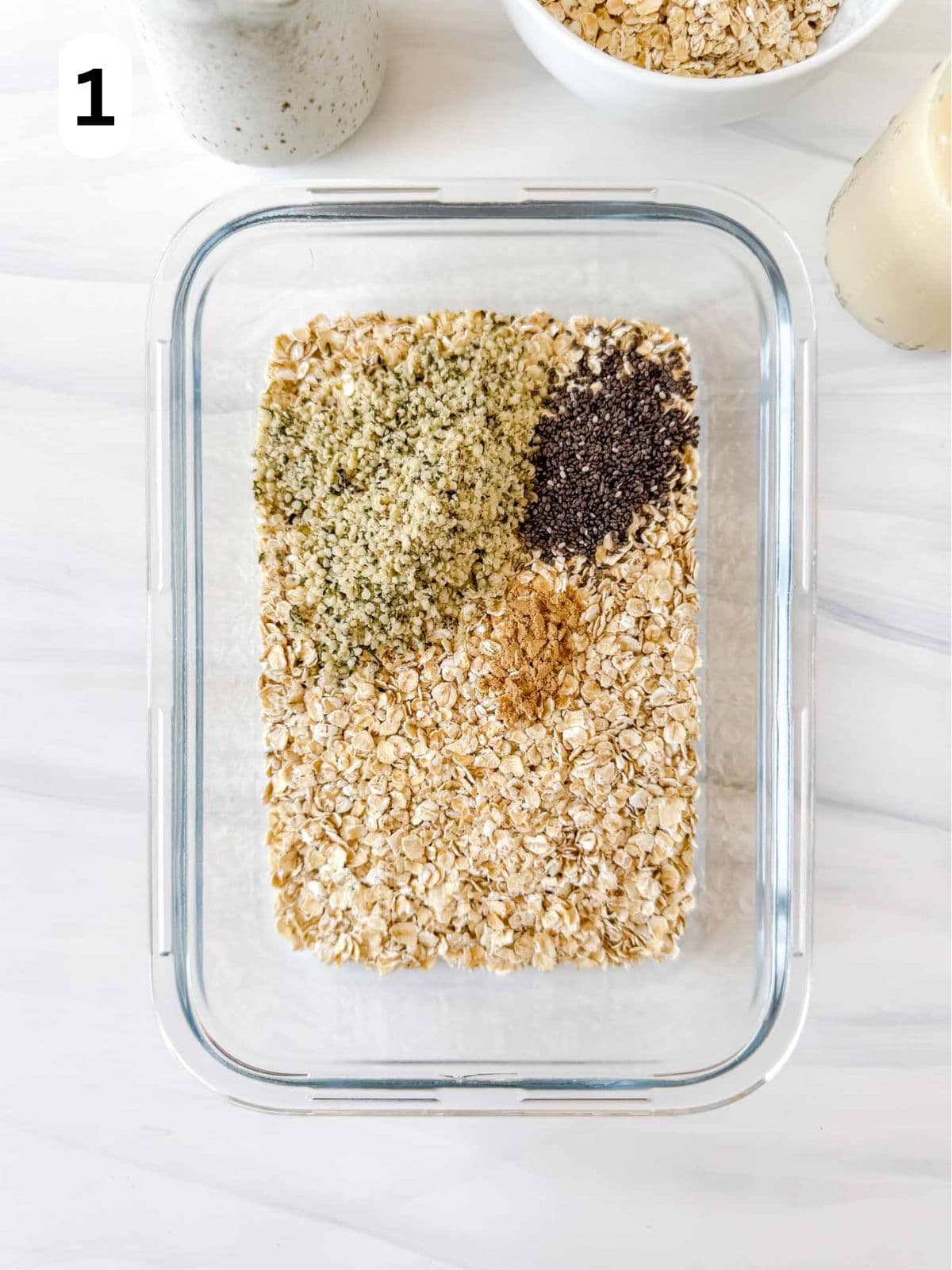 hemp seeds, oats, chia seeds and ground ginger in a glass dish labelled number one.