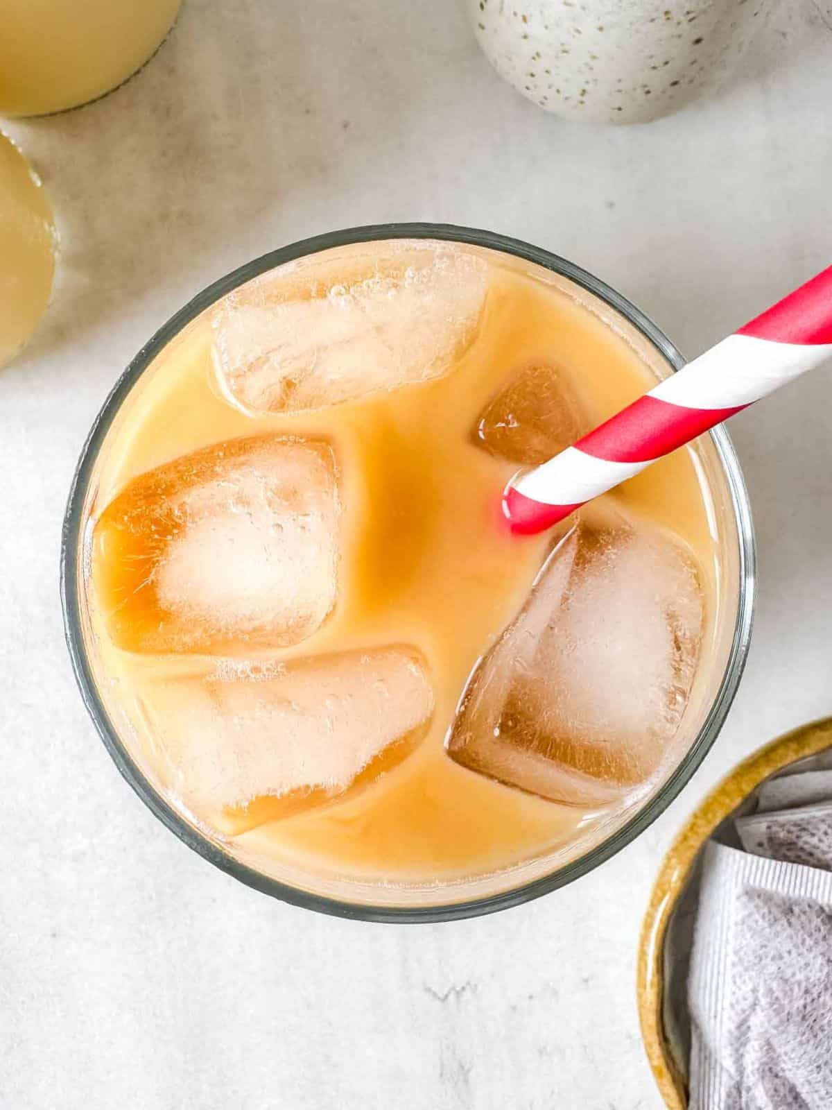 iced rooibos latter in a glass with a red and white straw.