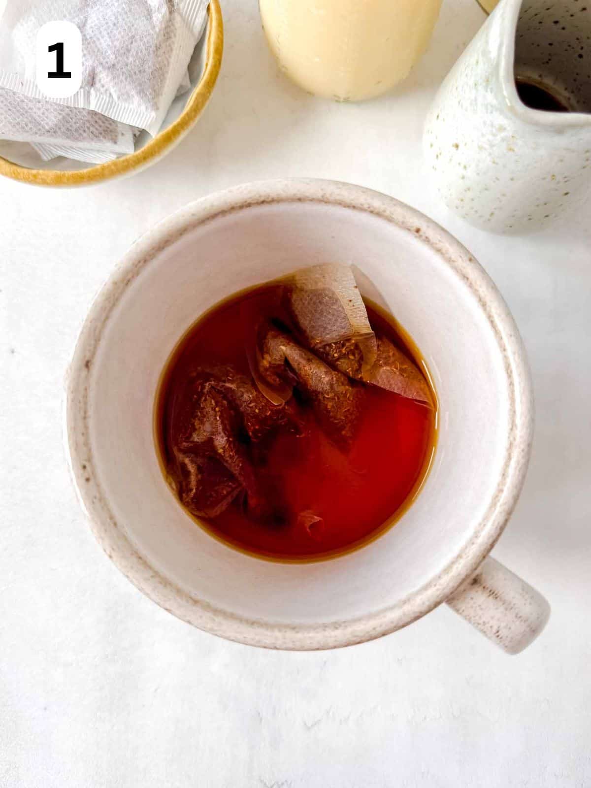 rooibos tea bags steeping in hot water in a mug labelled number one.