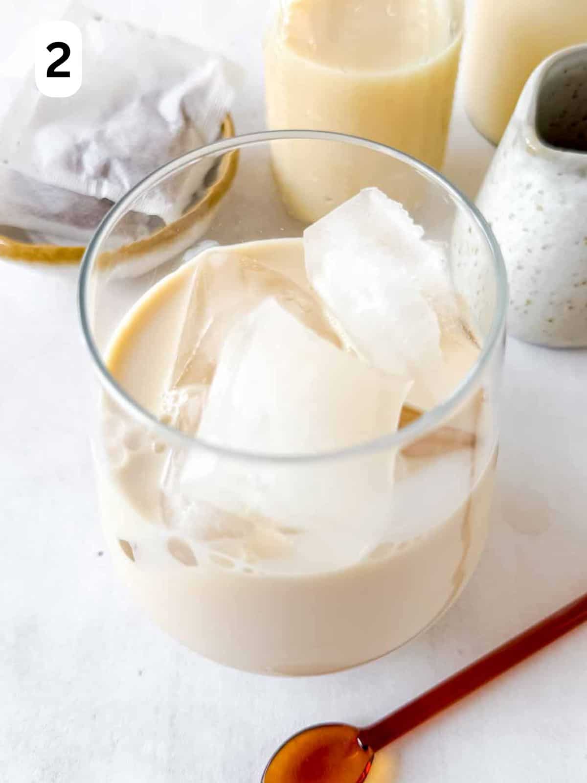 milk and ice cubes in a glass labelled number two.