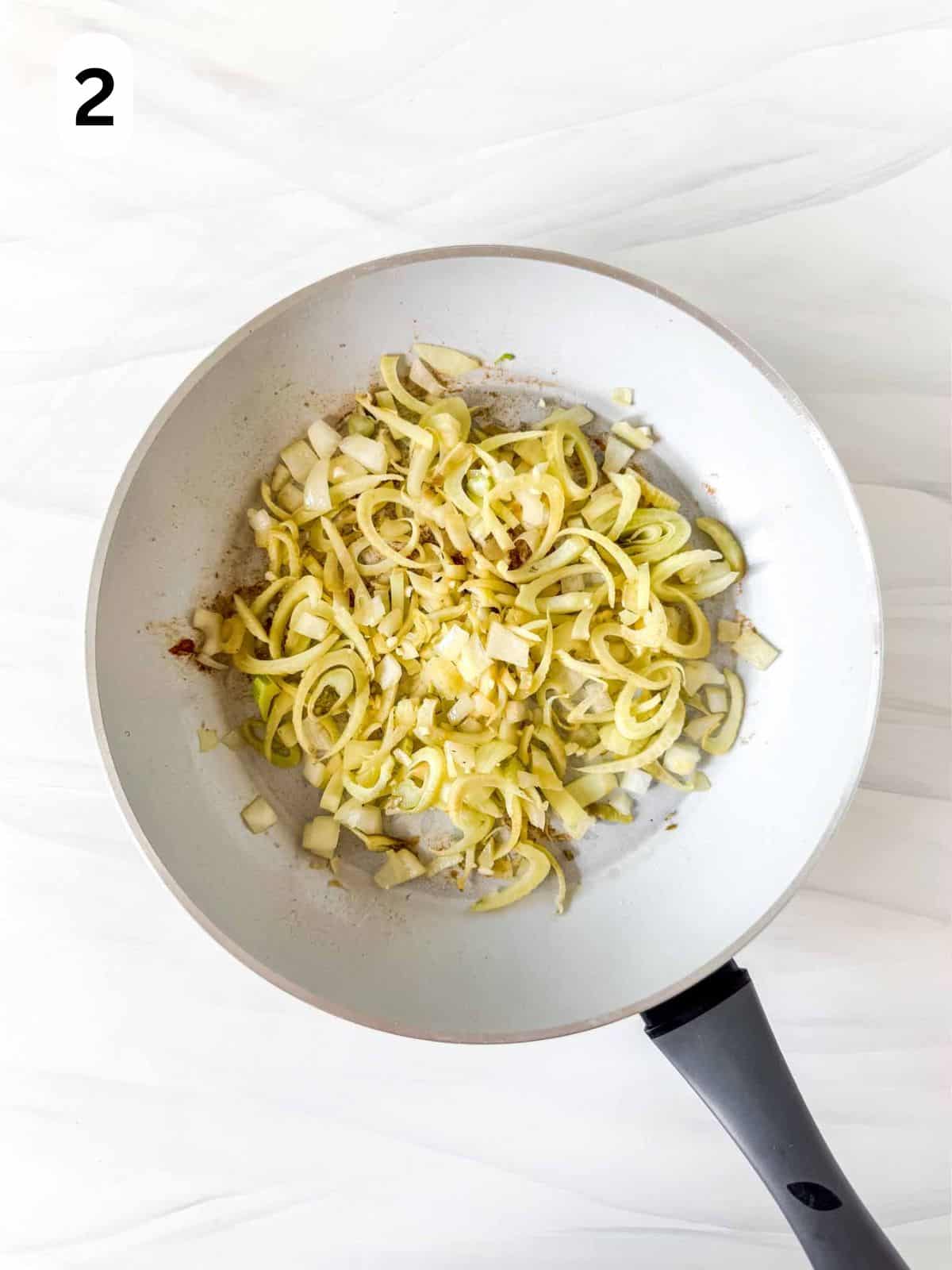 diced onion and fennel in a skillet labelled number two.