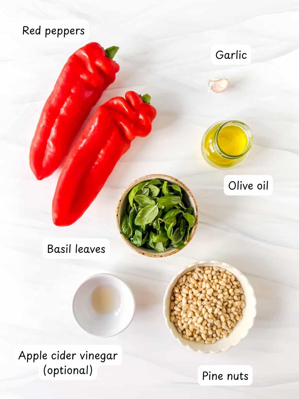 individually labelled red peppers, olive oil, garlic, basil leaves, pine nuts and apple cider vinegar.