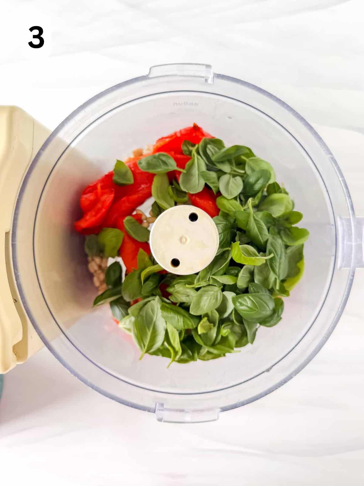 pine nuts, fresh basil leaves, roasted red peppers, olive oil and apple cider vinegar in a food processor labelled number three.
