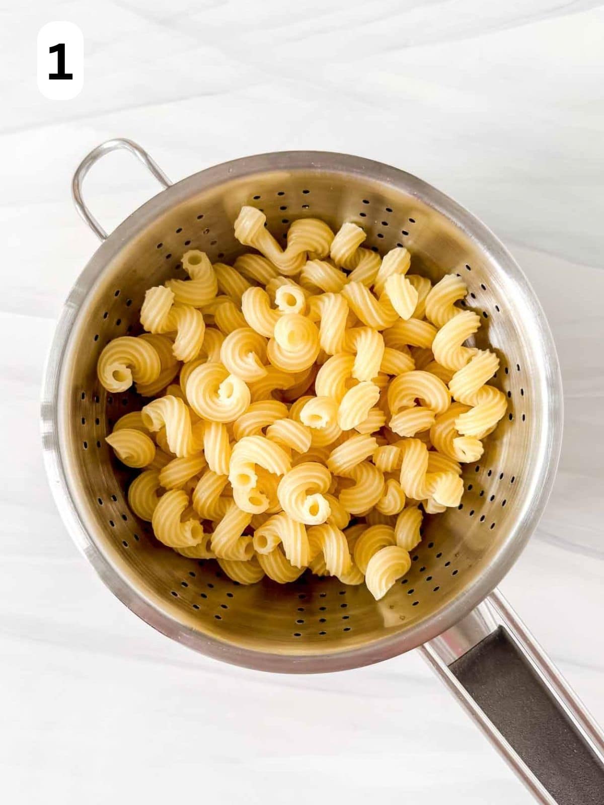 cooked pasta in a colander labelled number one.